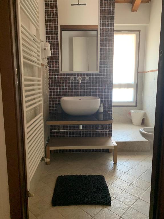 łazienka z wanną, umywalką i lustrem w obiekcie Casa Cleopatra w Bergamo