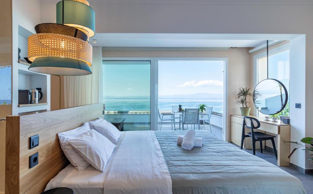 a bedroom with a bed with a view of the ocean at Briki Suites in Kallithea Halkidikis