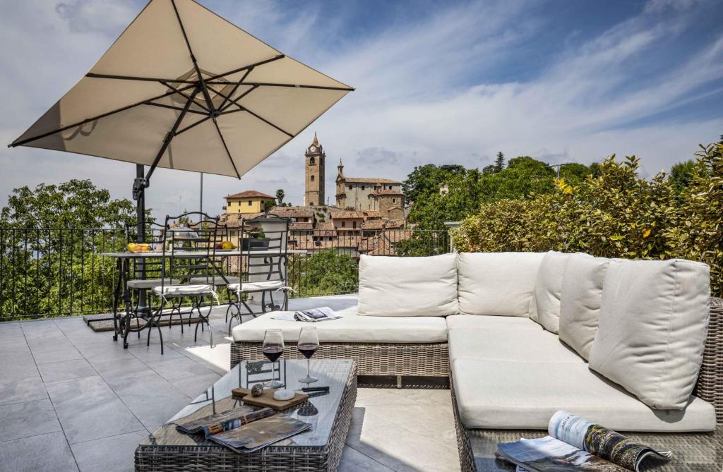 een woonkamer met een witte bank en een paraplu bij Villa Gremì - Monforte d'Alba in Monforte dʼAlba