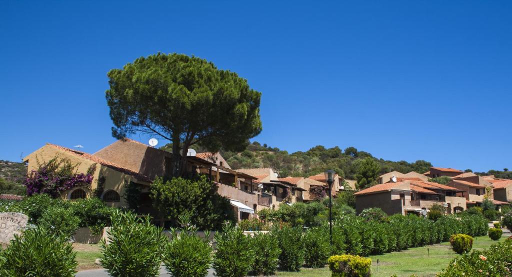 szereg domów z drzewem w wiosce w obiekcie Porto Ottiolu Resort w mieście Porto Ottiolu