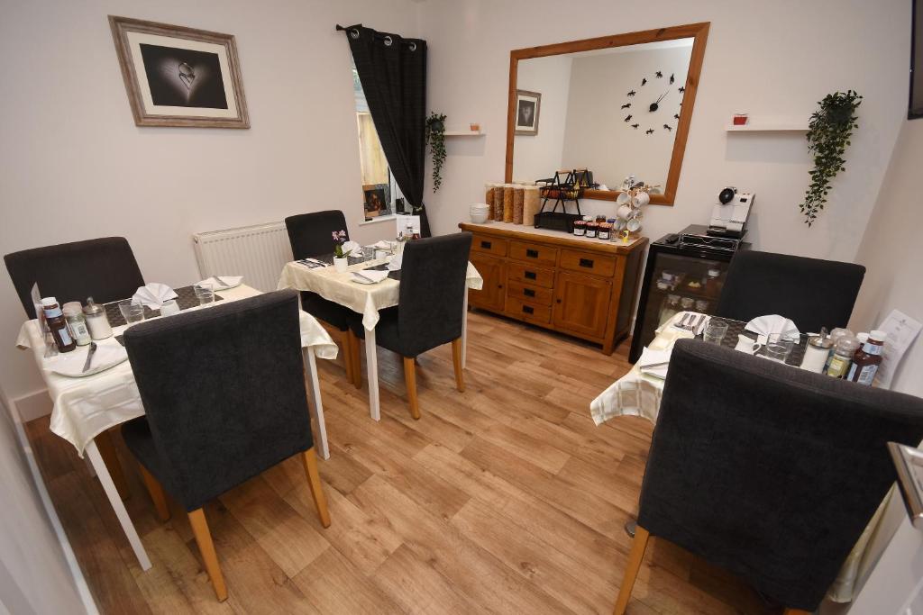 a room with tables and chairs and a mirror at Apple Tree Place B&B in Tadley