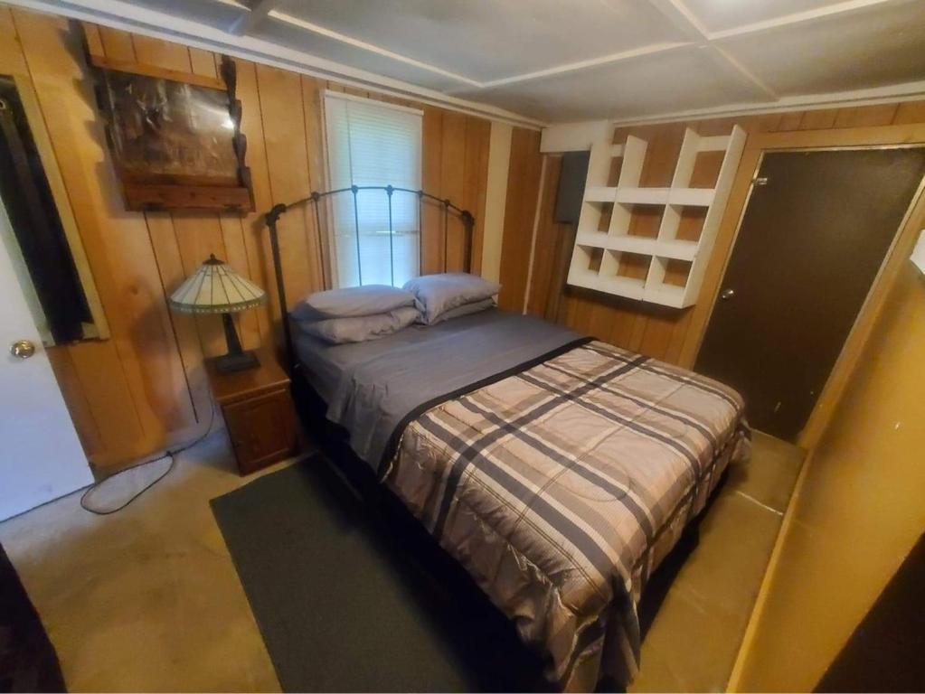a bedroom with a bed and a lamp in it at Cute Little Cabin (Near the Nantahala River) in Topton
