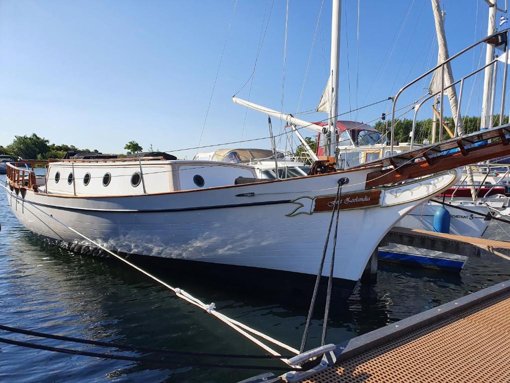 een witte boot is aangemeerd bij een dok bij Zeilklipper Fort Zeelandia in Kamperland