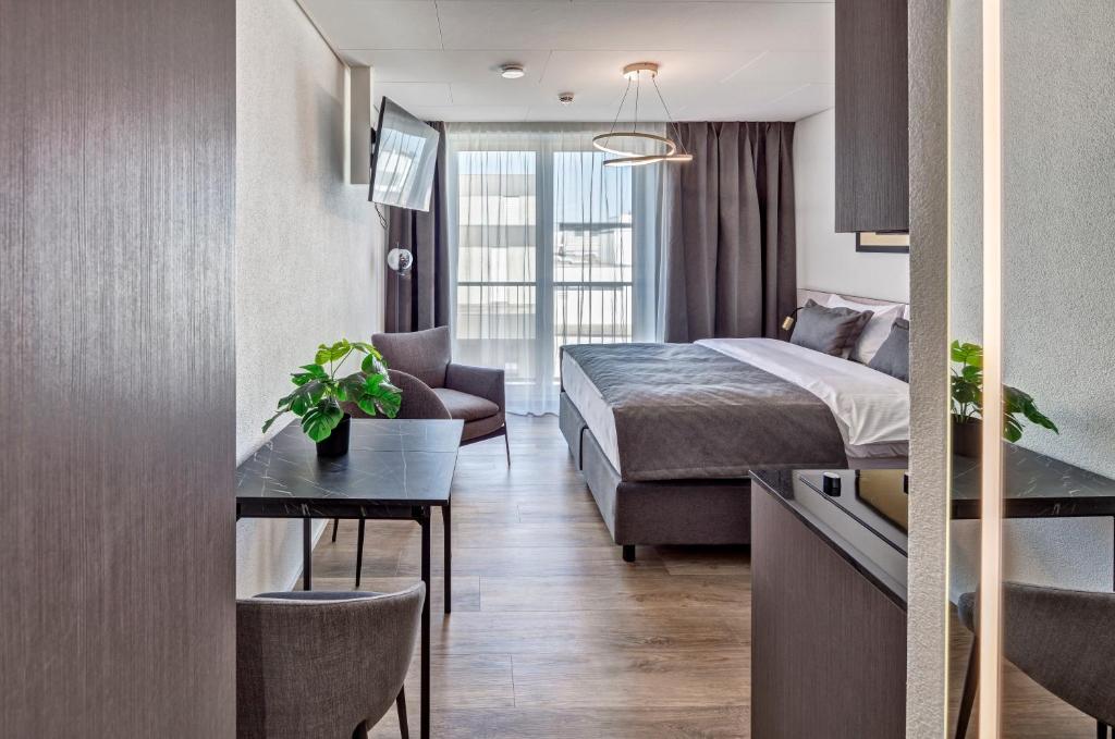 a hotel room with a bed and a table and a couch at MOOI Apartments Schlieren in Schlieren