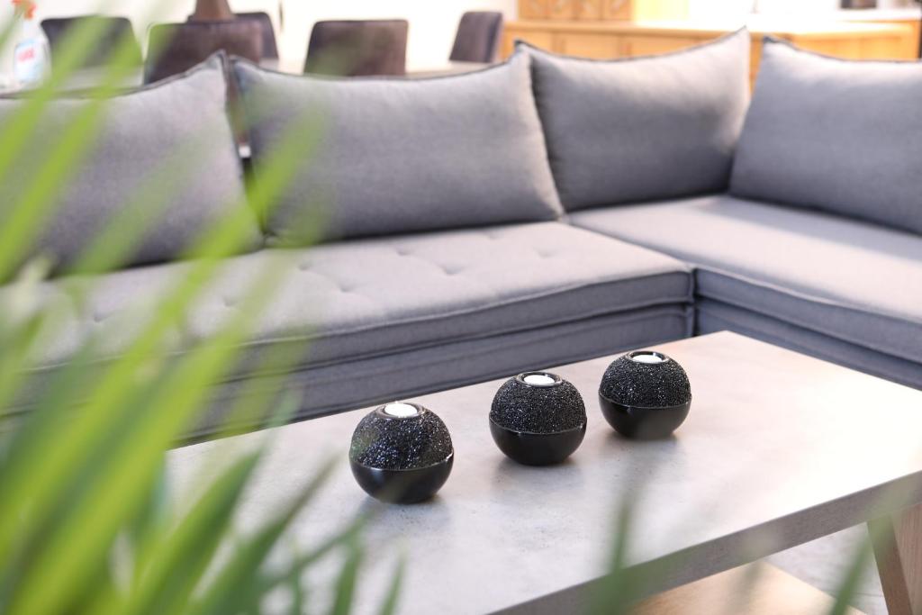 three black vases sitting on a table in front of a couch at White Pearl 1 in Petrití