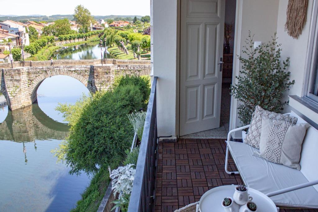 balcón con vistas a un puente y al agua en a casa da Alicia, en Monforte de Lemos
