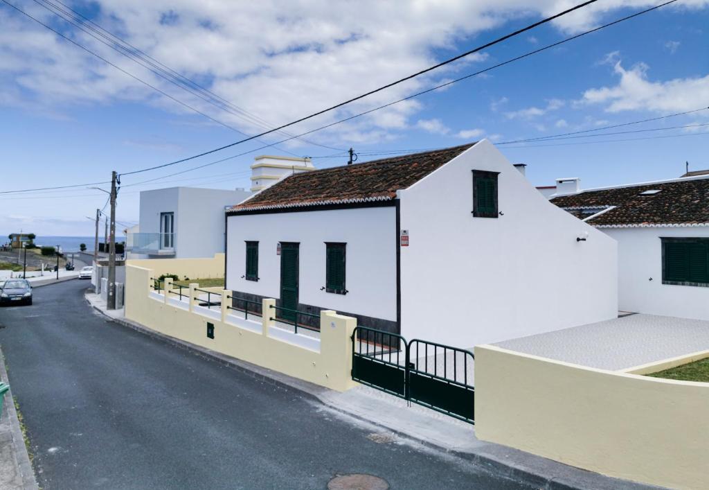 Ein weißes Haus an der Seite einer Straße in der Unterkunft Aurora House in Mosteiros