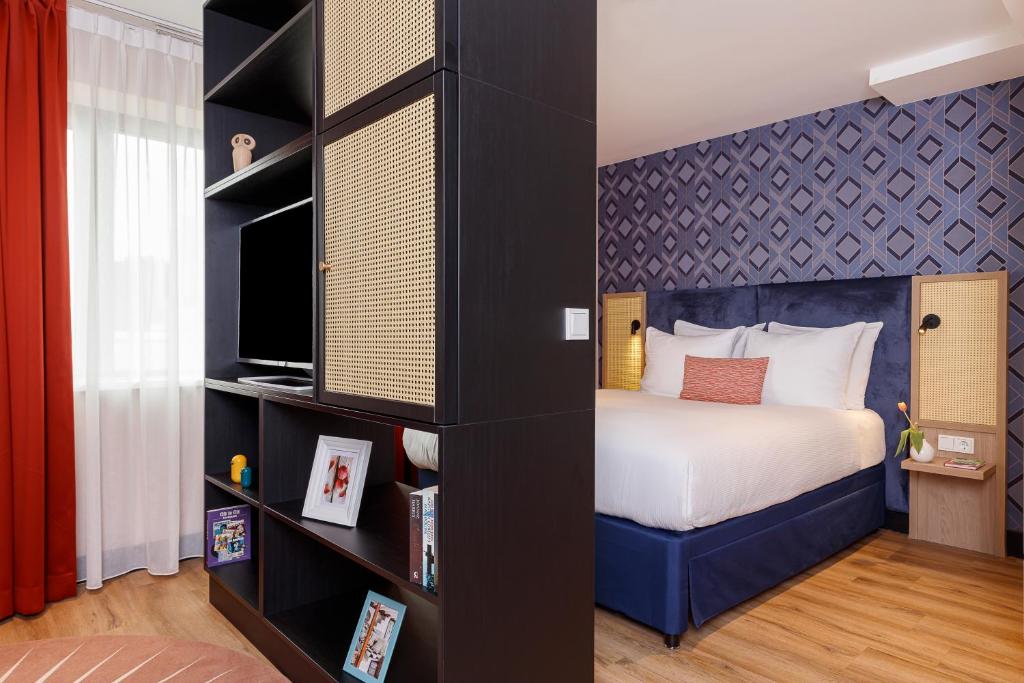 een slaapkamer met een bed en een boekenplank bij Boutique Apartments Amsterdam in Amsterdam