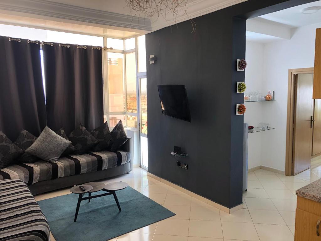 - un salon avec un canapé et une télévision dans l'établissement Large Sea view studio, à Agadir