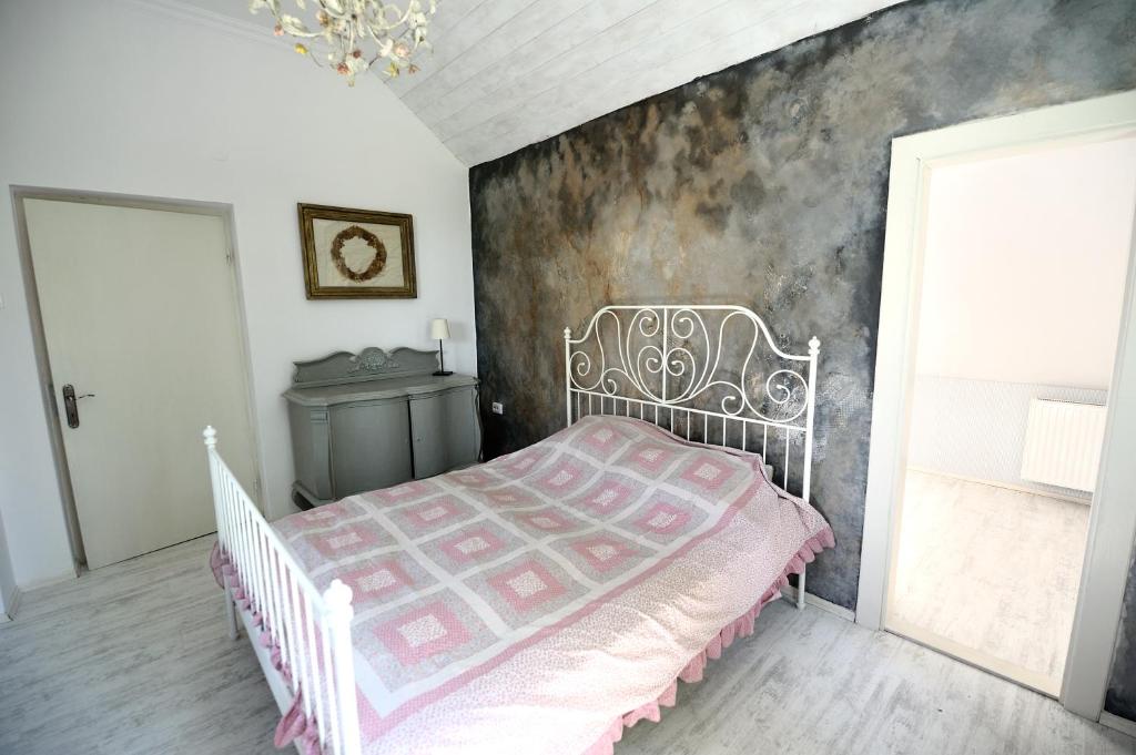 a bedroom with a white bed with a pink blanket at Levendula ház - Rosie Home in Balatonlelle