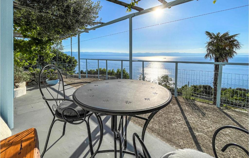 einen Tisch und Stühle auf einem Balkon mit Meerblick in der Unterkunft Awesome Apartment In Moscenice With Wifi in Mošćenice