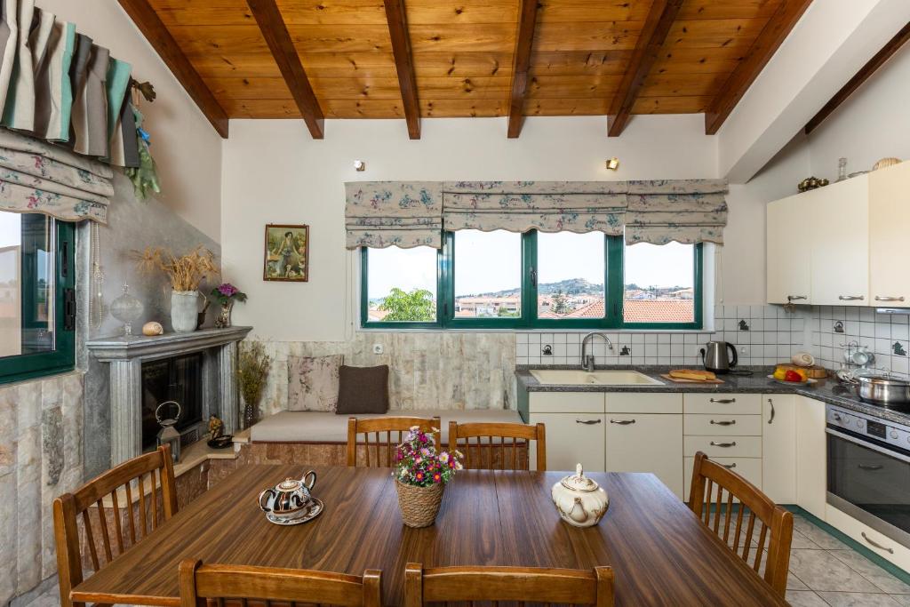 una cucina e una sala da pranzo con tavolo e sedie in legno di A&S Seaside Maisonette a Lixouri