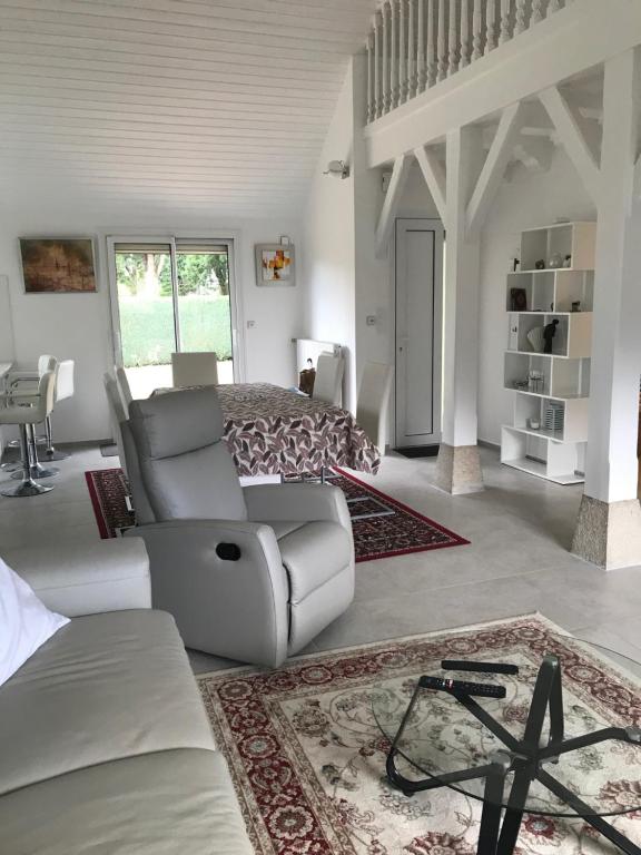 uma sala de estar com uma cama e um sofá em Maison moderne 8 personnes, jardin, parkings, fibre THD, plage 5 min em Vannes