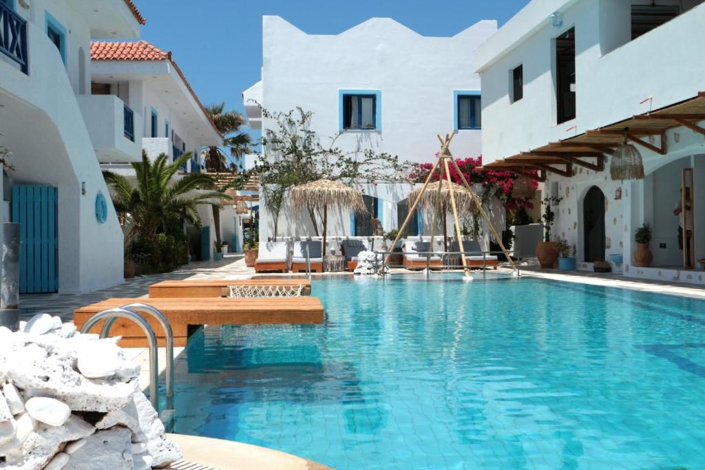 - une piscine dans un hôtel avec des bâtiments blancs dans l'établissement OV Suites "by Checkin", à Chersónissos