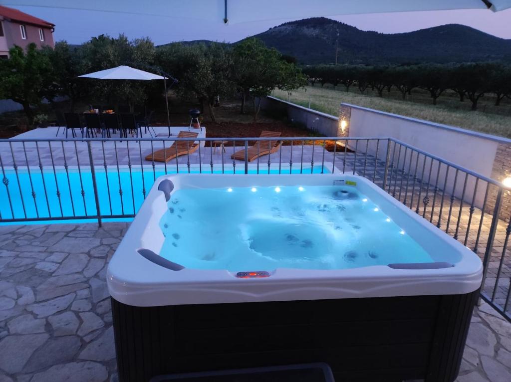 bañera de hidromasaje en un patio junto a la piscina en Villa bazen,jacuzzy, en Sukošan