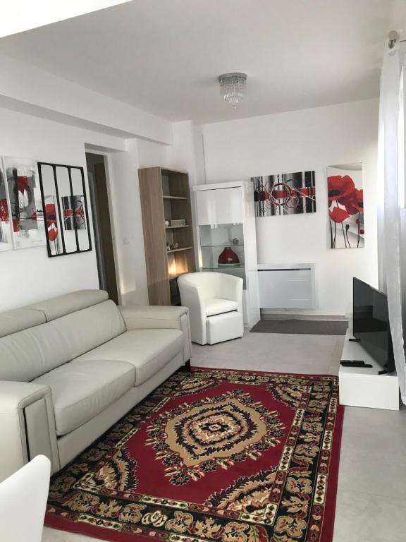 sala de estar con sofá blanco y alfombra roja en Maison "lumière et confort" 6 pers, parkings, jardin, fibre optique, 5 min plage, en Vannes