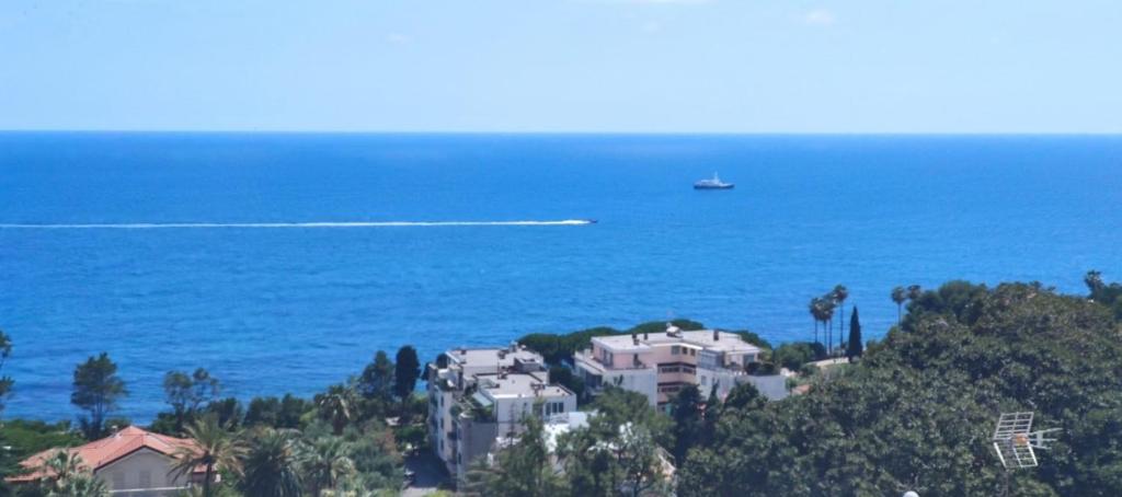 ein Haus auf einem Hügel in der Nähe des Ozeans mit einem Boot in der Unterkunft Carlo's BA27 - Sanremo Attico Cielo Mare - in Sanremo