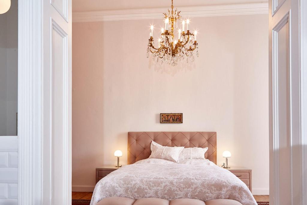 霍恩的住宿－Exklusiver, privater Schlosstrakt im Schloss Horn，一间卧室配有一张带吊灯的大床