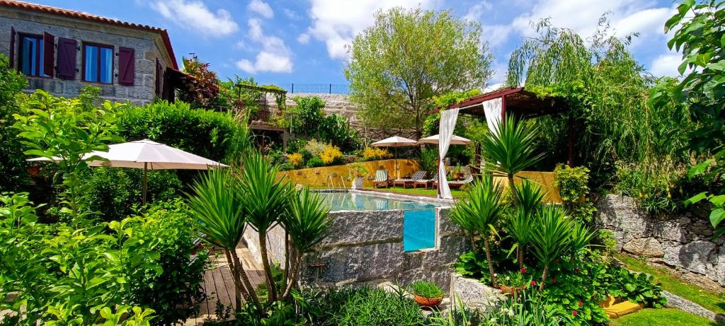 a garden with a swimming pool and a house at Casa da Benfeitoria in Guimarães