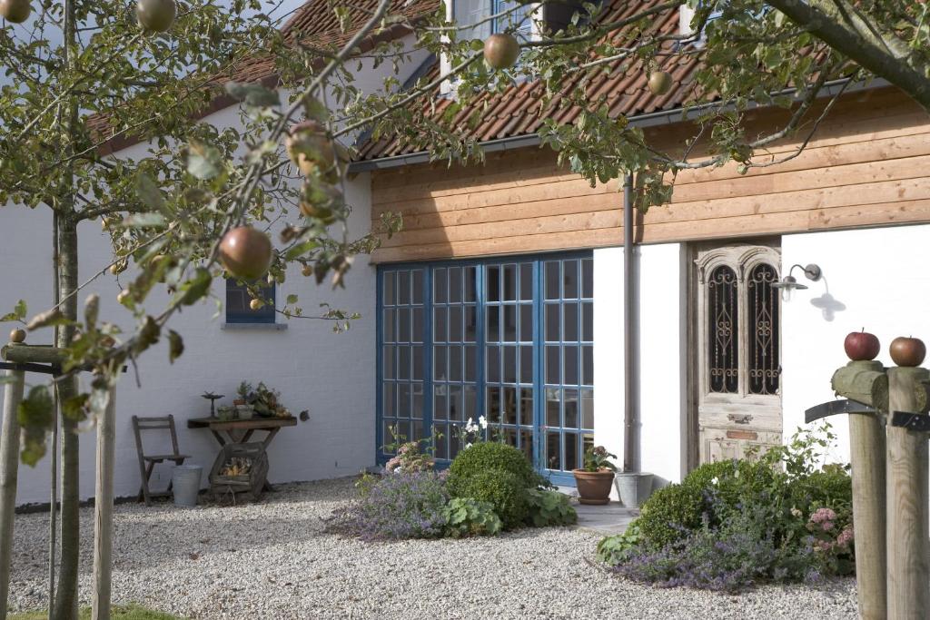 a white house with a large glass door at Boutique B&B Droomkerke in Ruiselede