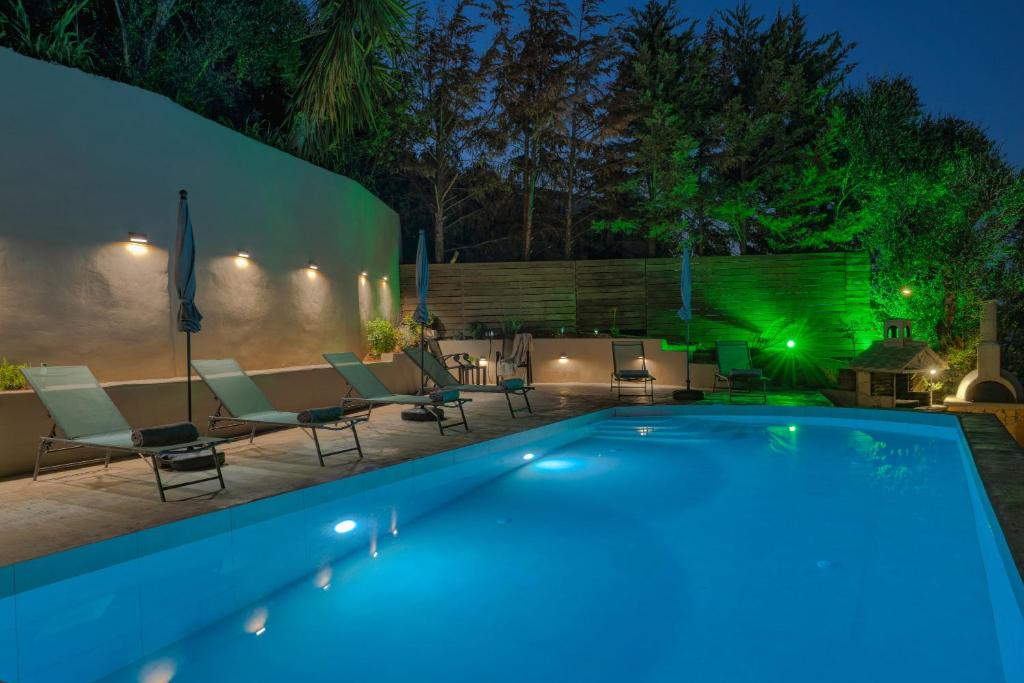 a swimming pool in a backyard at night at Sea View Villa in Katastárion