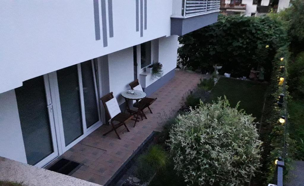 um pátio exterior com cadeiras e uma mesa num edifício em Apartma Julija em Luče