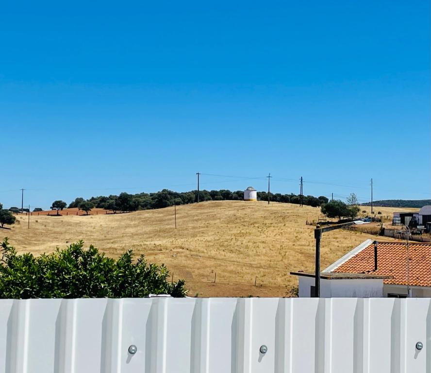 a view of a field with a white fence at Casa do Carmo in Sousel