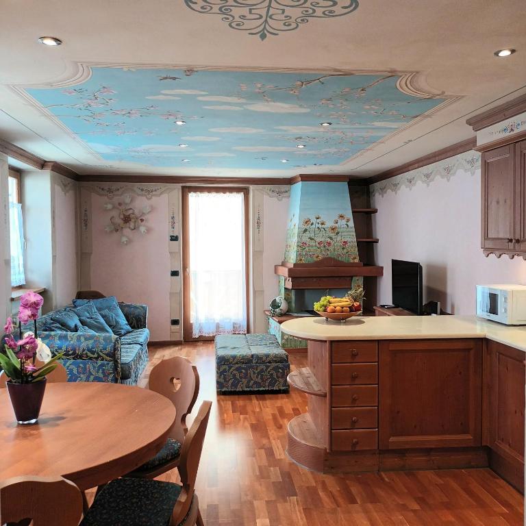 a kitchen and living room with a table and a couch at Il nido incantato in Andalo