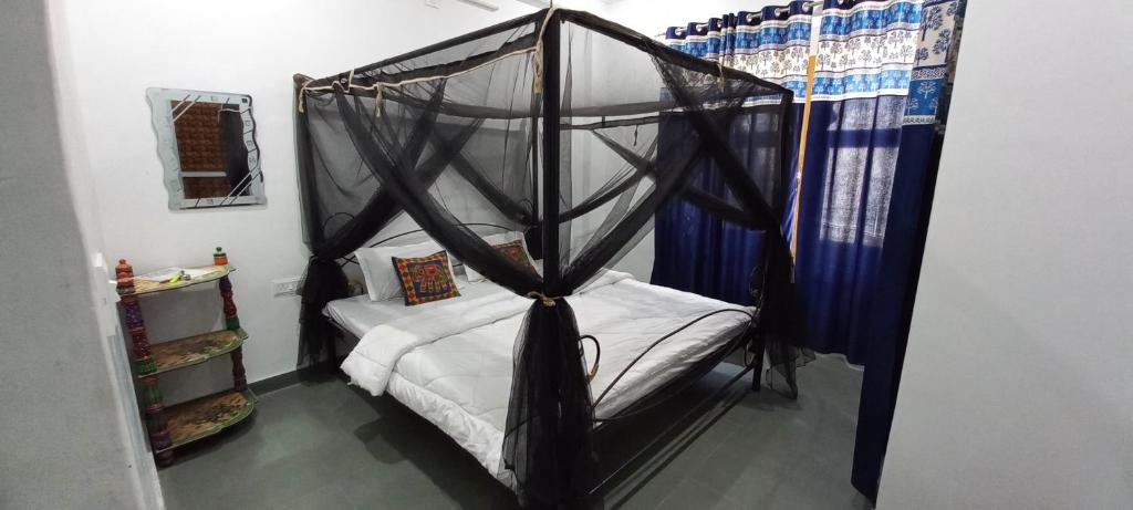 1 dormitorio con 1 cama con dosel en Hill Paradise Home Stay en Udaipur