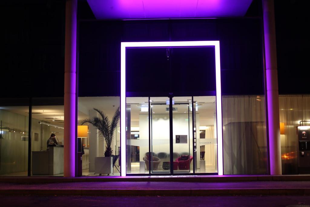 un edificio con una puerta iluminada por la noche en arte Hotel Linz en Linz