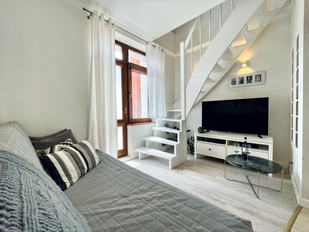 uma sala de estar com uma cama e uma televisão em Two-story Old Town Apartment em Toruń