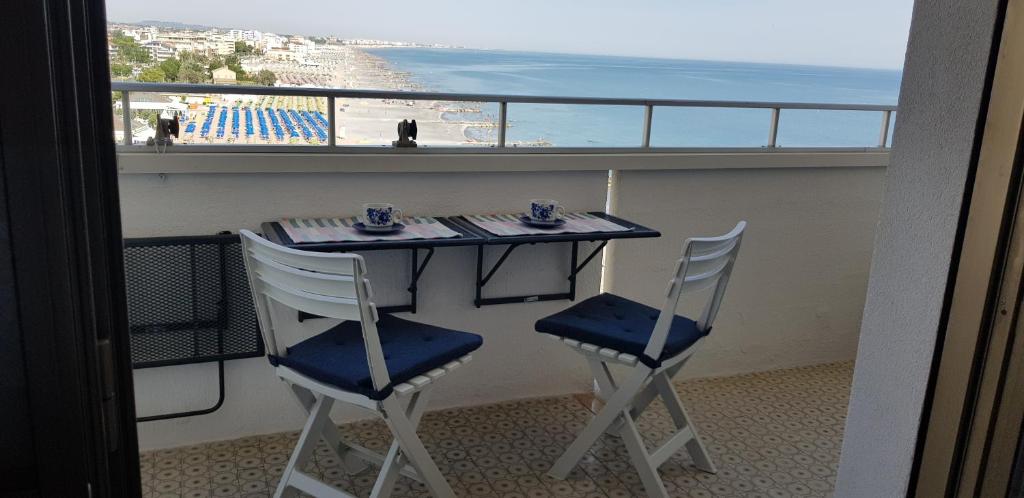 d'une table et de chaises sur un balcon avec vue sur la plage. dans l'établissement SUL MARE..., à Misano Adriatico