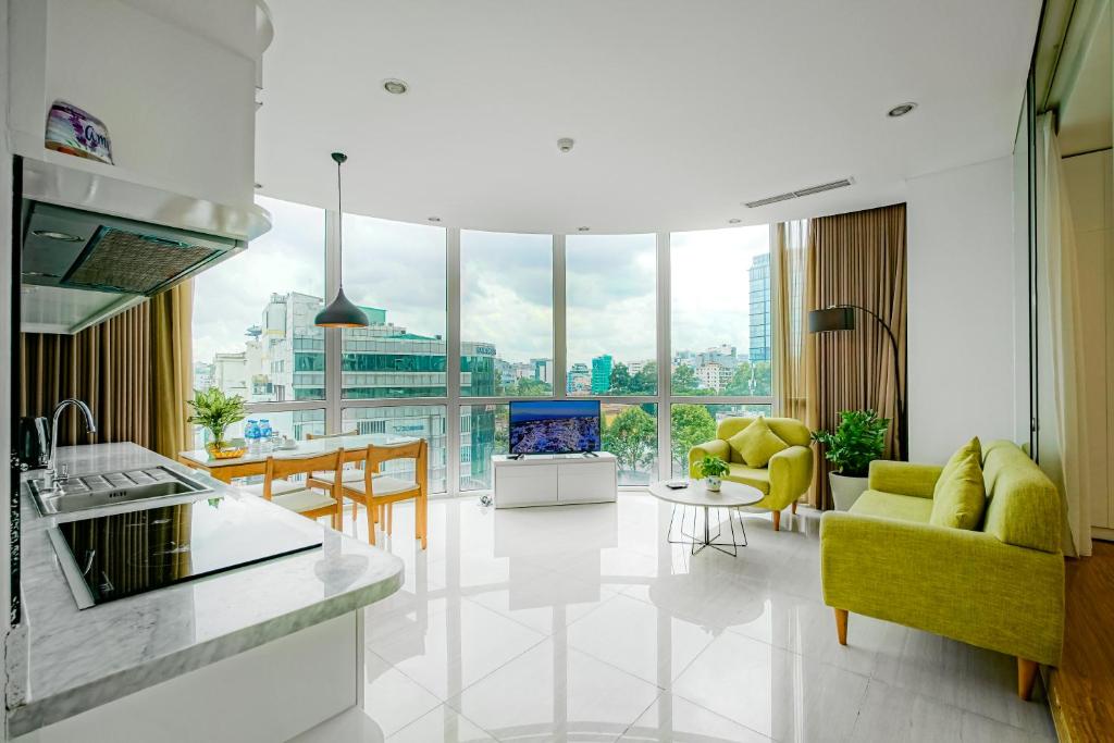 Il comprend une cuisine et un salon avec une grande fenêtre. dans l'établissement City By Night Ben Thanh Apartments, à Hô-Chi-Minh-Ville