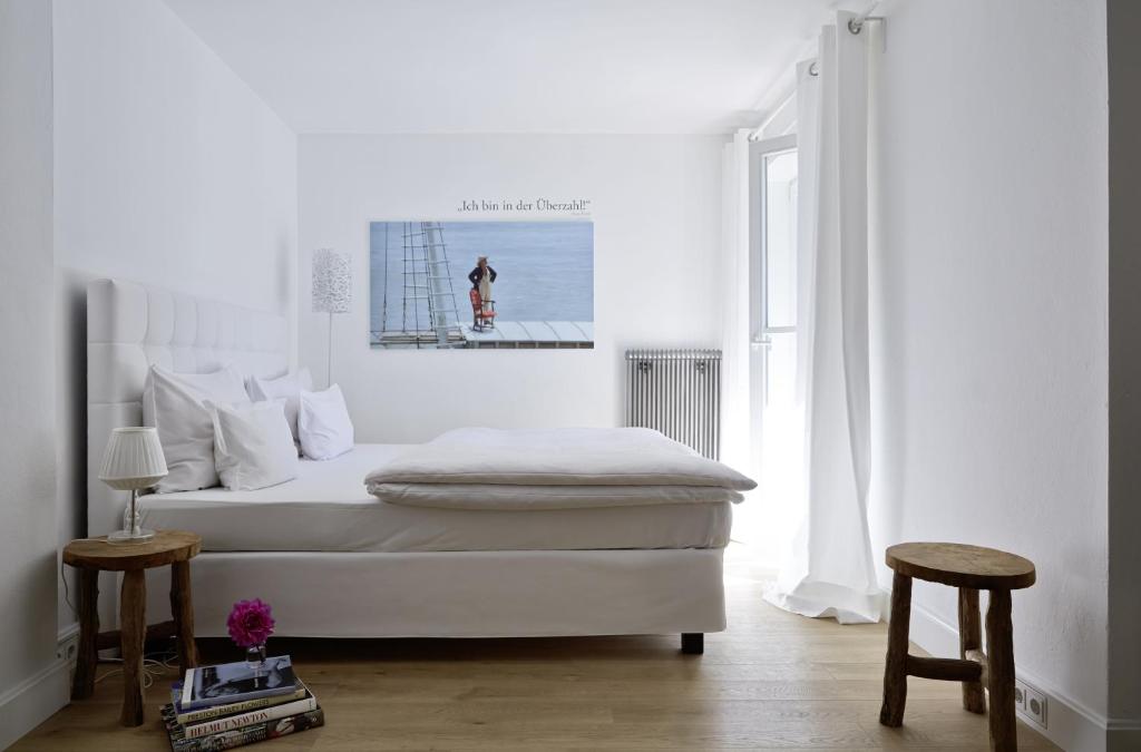 a white bedroom with a bed and a window at Hotel Der Seehof in Goldegg