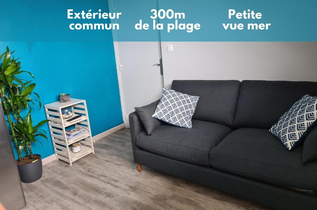 um sofá numa sala de estar com uma parede azul em Joli appartement - 4min à pieds de la plage em Asnelles