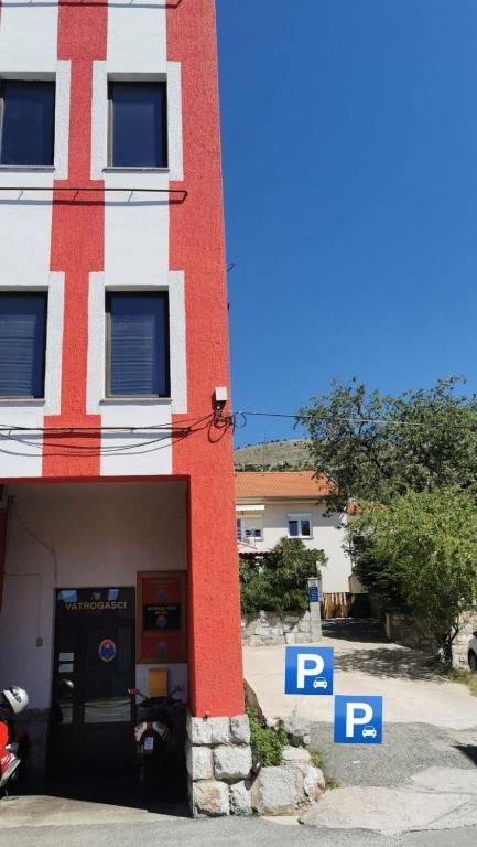 a red and white building with parking signs in front of it at Jasmina in Senj
