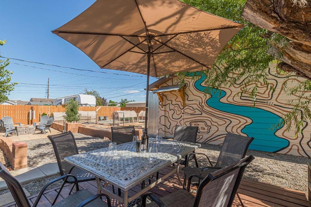 uma mesa com um guarda-chuva em frente a um mural em Topo - In-town Rancher W- Backyard Oasis! em Fruita