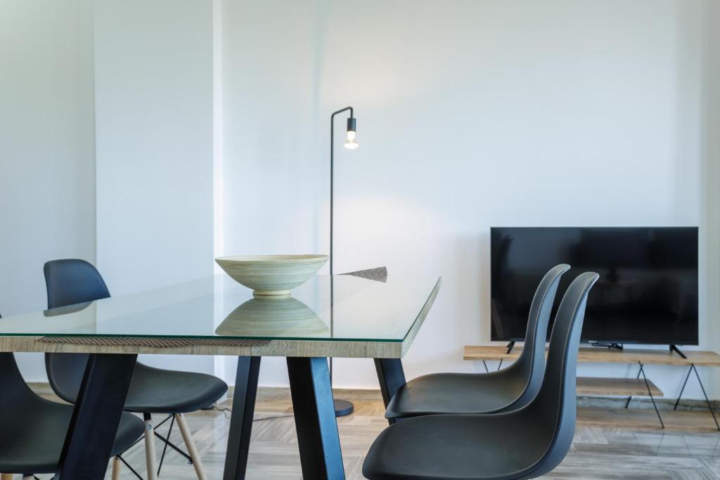 a dining room with a glass table and chairs at La Pietra Verga in Kalamata