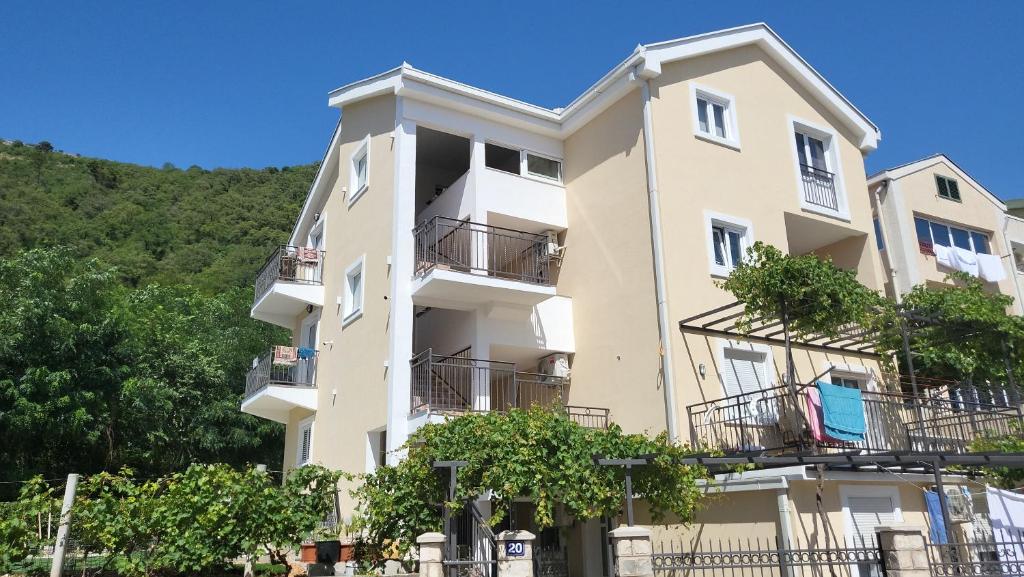 an apartment building with balconies and trees at Apartmani Mia Sorajic in Petrovac na Moru
