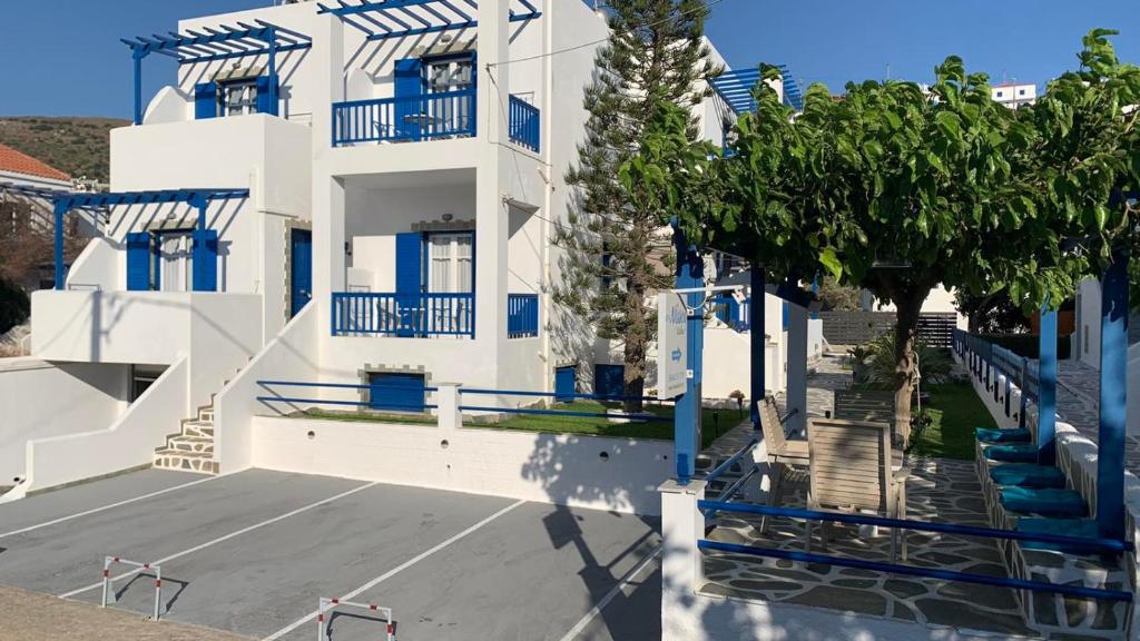 巴特斯歐的住宿－Nissea Studios - πρώην Dora 2 Studios -，白色的建筑,设有蓝色的阳台和停车场