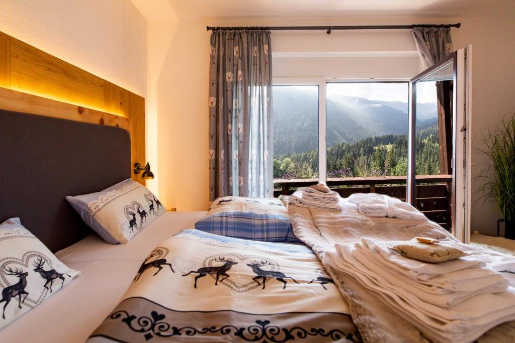 a bedroom with two beds and a large window at Bergblick Ruhe und Aussicht auf 1100m in Sankt Lorenzen ob Murau