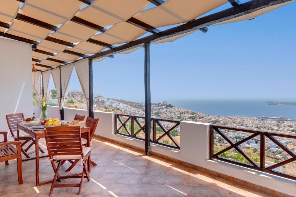 - une vue depuis le balcon d'une maison avec une table et des chaises dans l'établissement Vera Vista Syros, à Áno Sýros