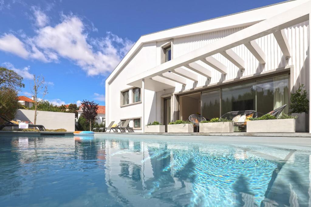 a house with a swimming pool in front of a building at Santa Joana Apartments with garden and heated pool in Lisbon
