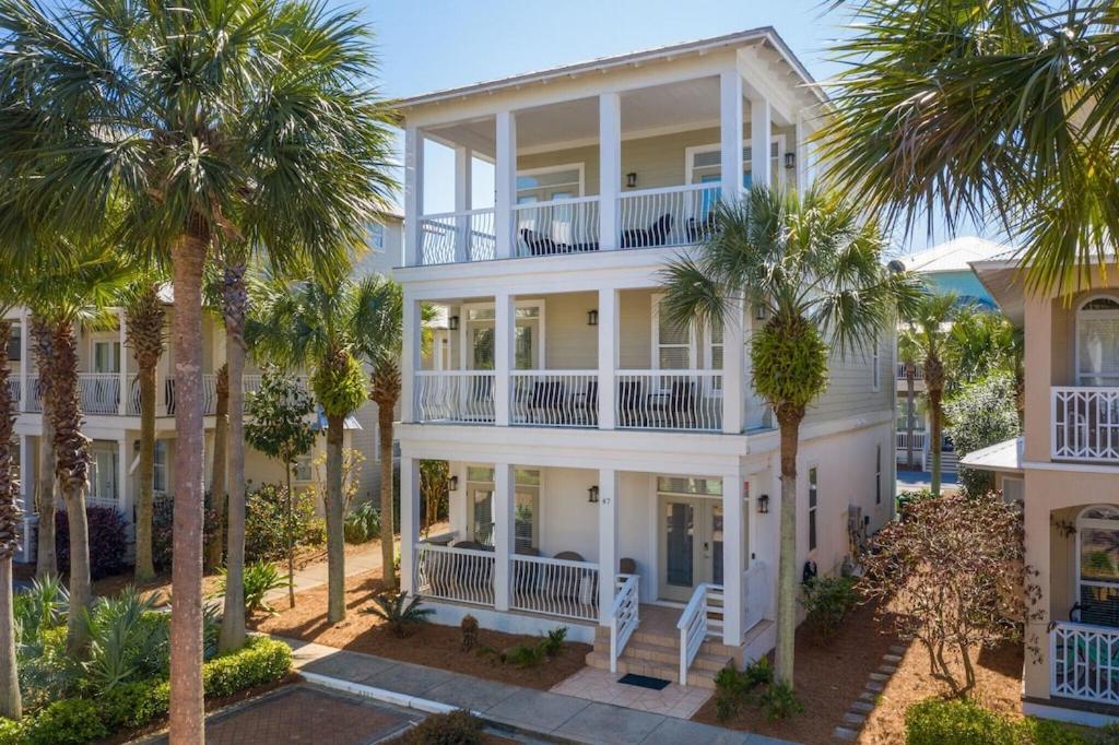 a large white house with palm trees in front of it at Seacrest Getaway in Rosemary Beach