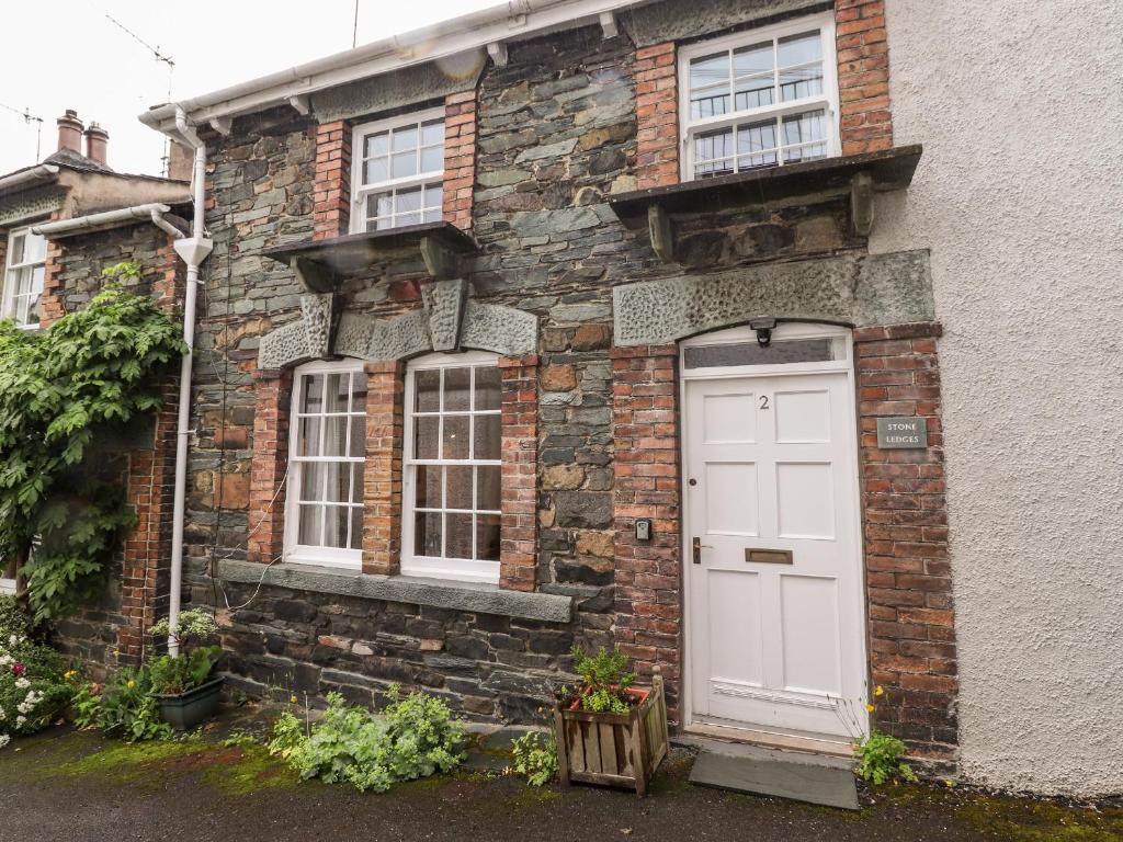 une maison en briques avec une porte et des fenêtres blanches dans l'établissement Stone Ledges, à Keswick