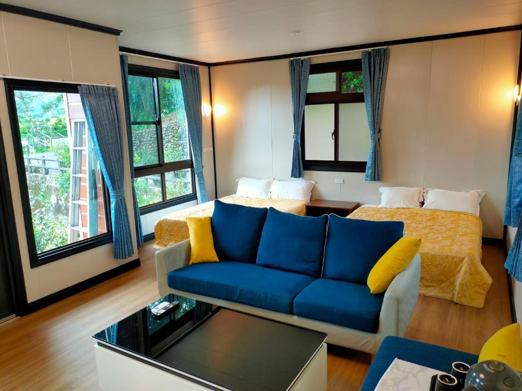 大同的住宿－茶鄉園民宿，客厅配有蓝色的沙发和黄色的枕头。