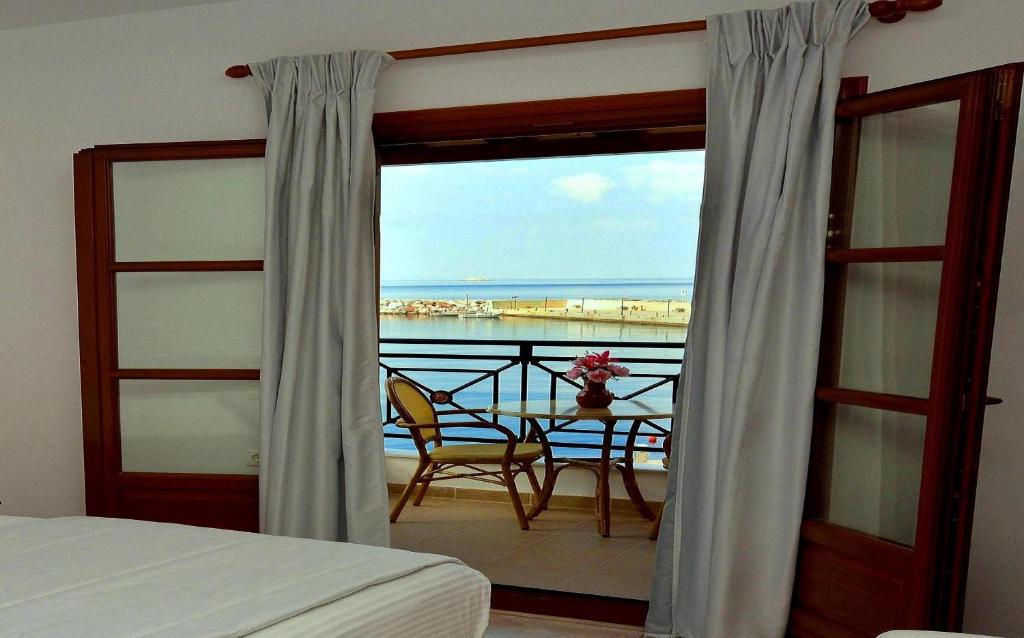 a bedroom with a balcony with a view of the ocean at Anna Maria - Vanessa Apartments in Neo Klima
