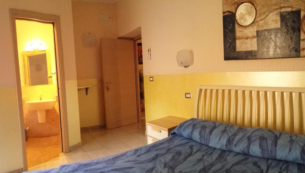 1 dormitorio con 1 cama y baño con lavamanos en B&B Lo Sparviero, en Civita