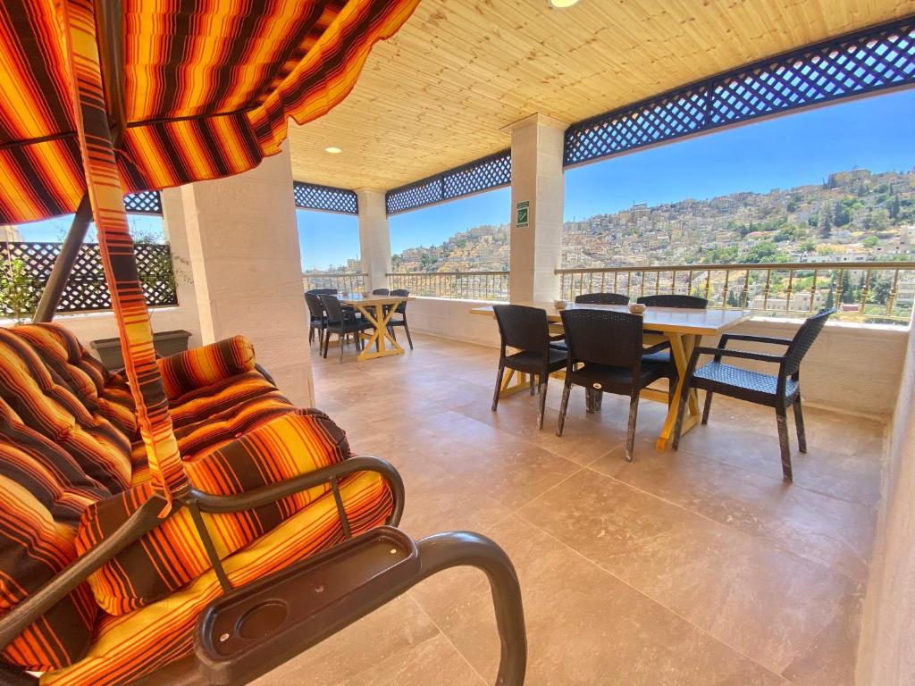Zimmer mit einem Tisch und Stühlen auf einem Balkon in der Unterkunft Villa Mira GuestHouse 2 - Downtown Central Amman - AL DIYRIH in Amman