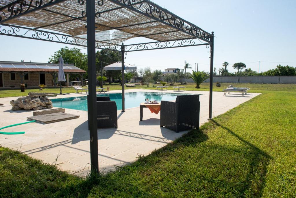 een pergola boven een zwembad in een tuin bij Villa dei Bruno in San Donato di Lecce